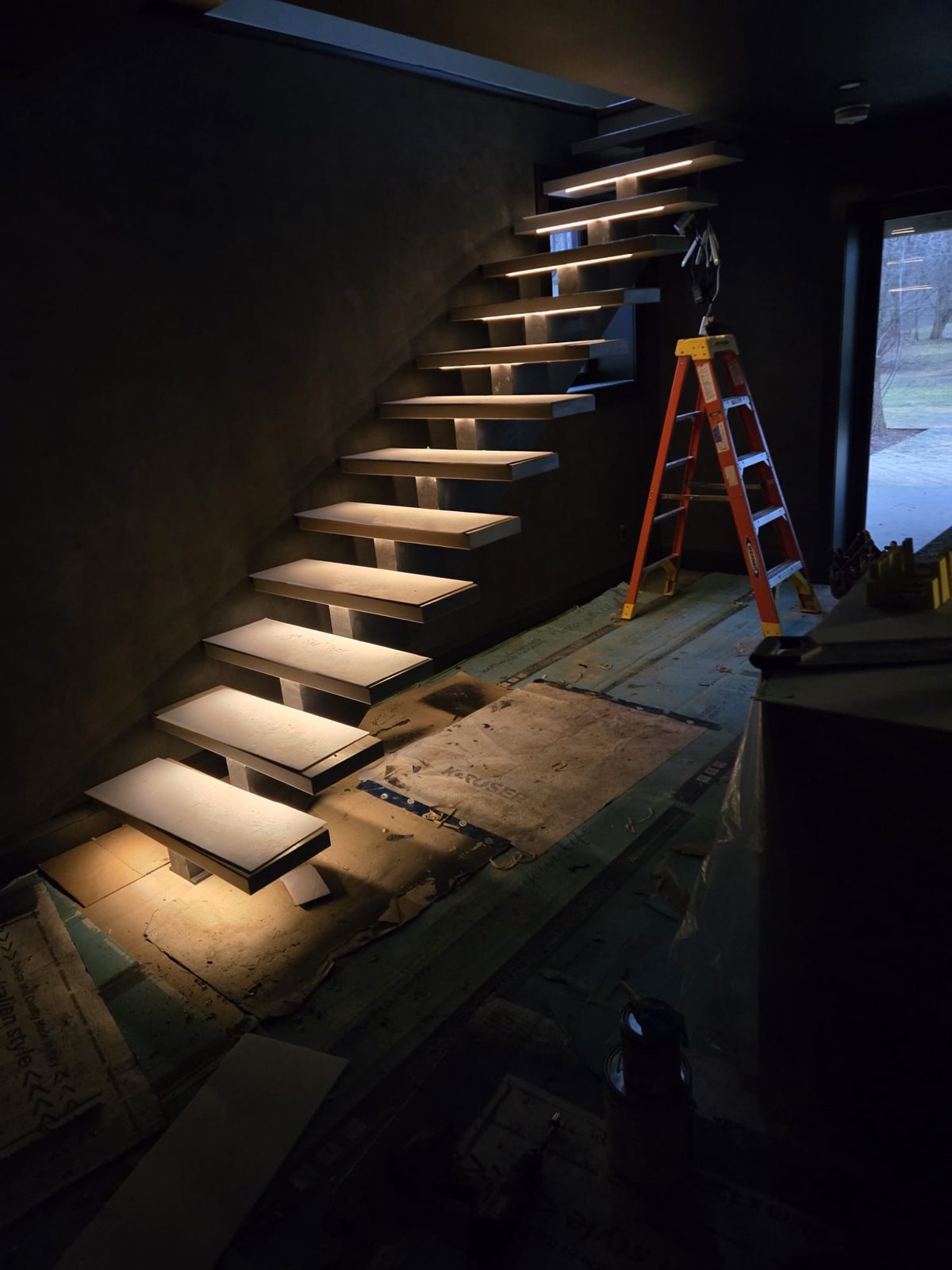 Stair lighting mid-install with a ladder on site, by HausPower